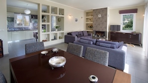 A modern living room with a dining table, sofas, and a fireplace. - Spacious villa with privacy and mountain views, near Agia Efimia & Myrtos beach (Makriotika, Kefalonia)