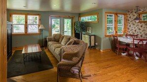 A spacious living room with a sofa, chairs, a small table, and a dining area with a table and chairs. - Perfect for an anniversary trip! (Lakebay)