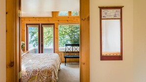 A bedroom with a bed, a window, and a view of trees. - Perfect for an anniversary trip! (Lakebay)