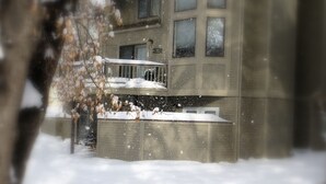 A building with multiple windows and balconies covered in snow.