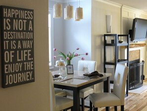 Enjoy meals in this stylish dining area with a dining table, comfortable chairs, and a fireplace.