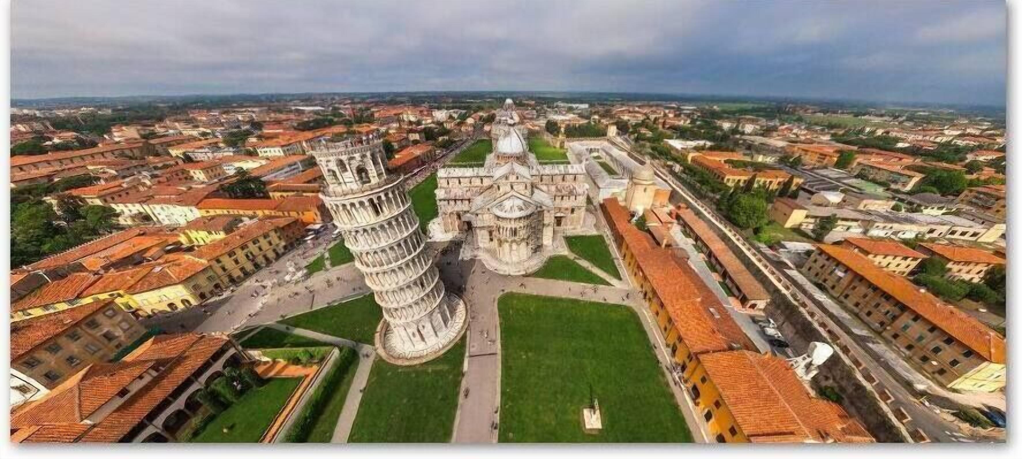 Vista aérea de una ciudad histórica con destacados monumentos arquitectónicos, incluyendo una alta torre de campanas y una catedral.