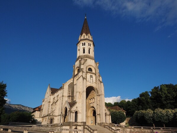 A large stone church with a tall bell tower, arched windows, and a prominent entrance.