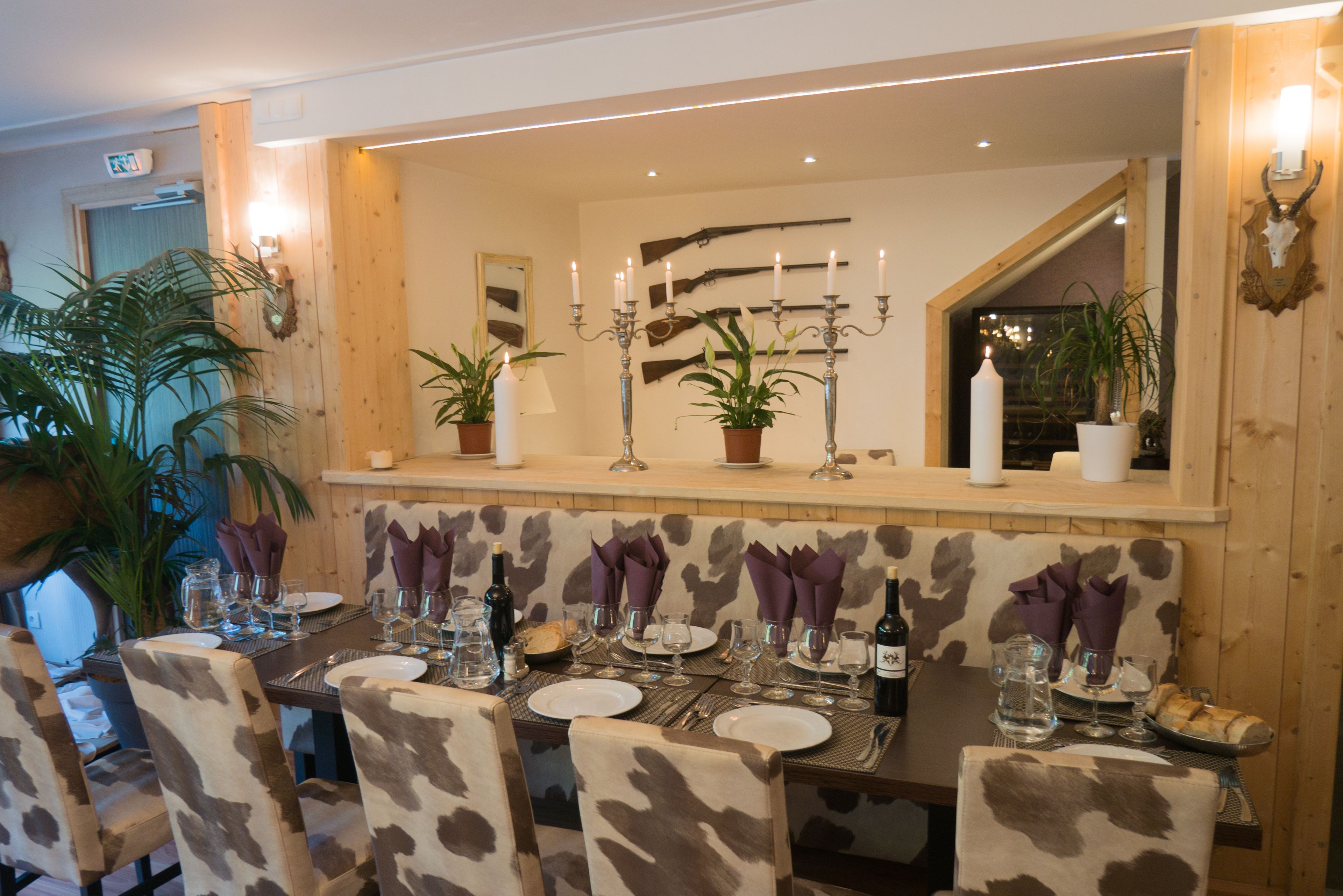 A dining area with a long table set for multiple guests, surrounded by chairs with a camouflage pattern.