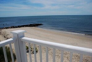 A beach with a white railing, clear blue sky, and calm sea. - Oceanfront duplex sleeping 6-breathtaking views of Nantucket Sound (Dennis Port)