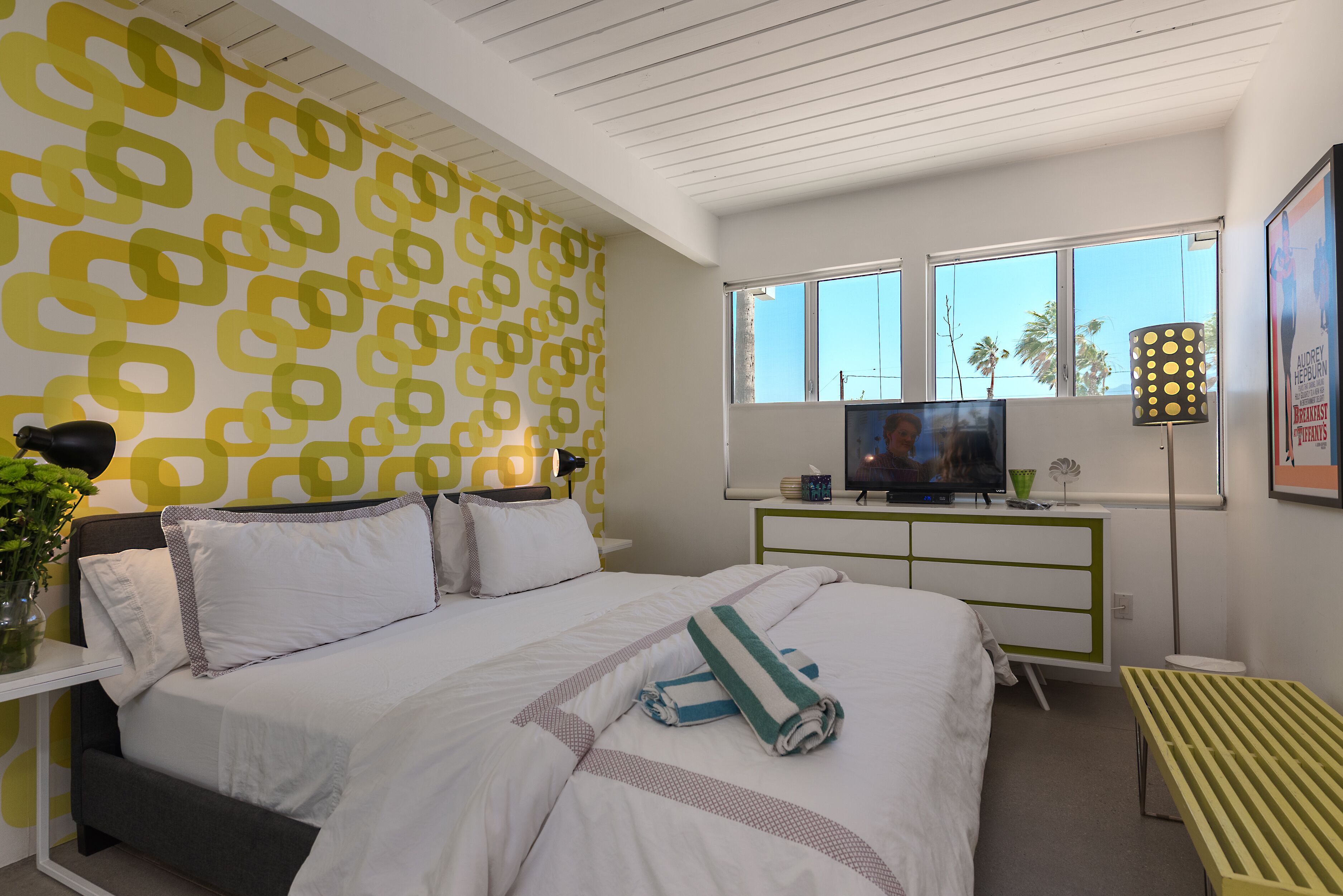 Une chambre moderne avec un lit, une télévision, un bureau et une fenêtre donnant sur un beau paysage.