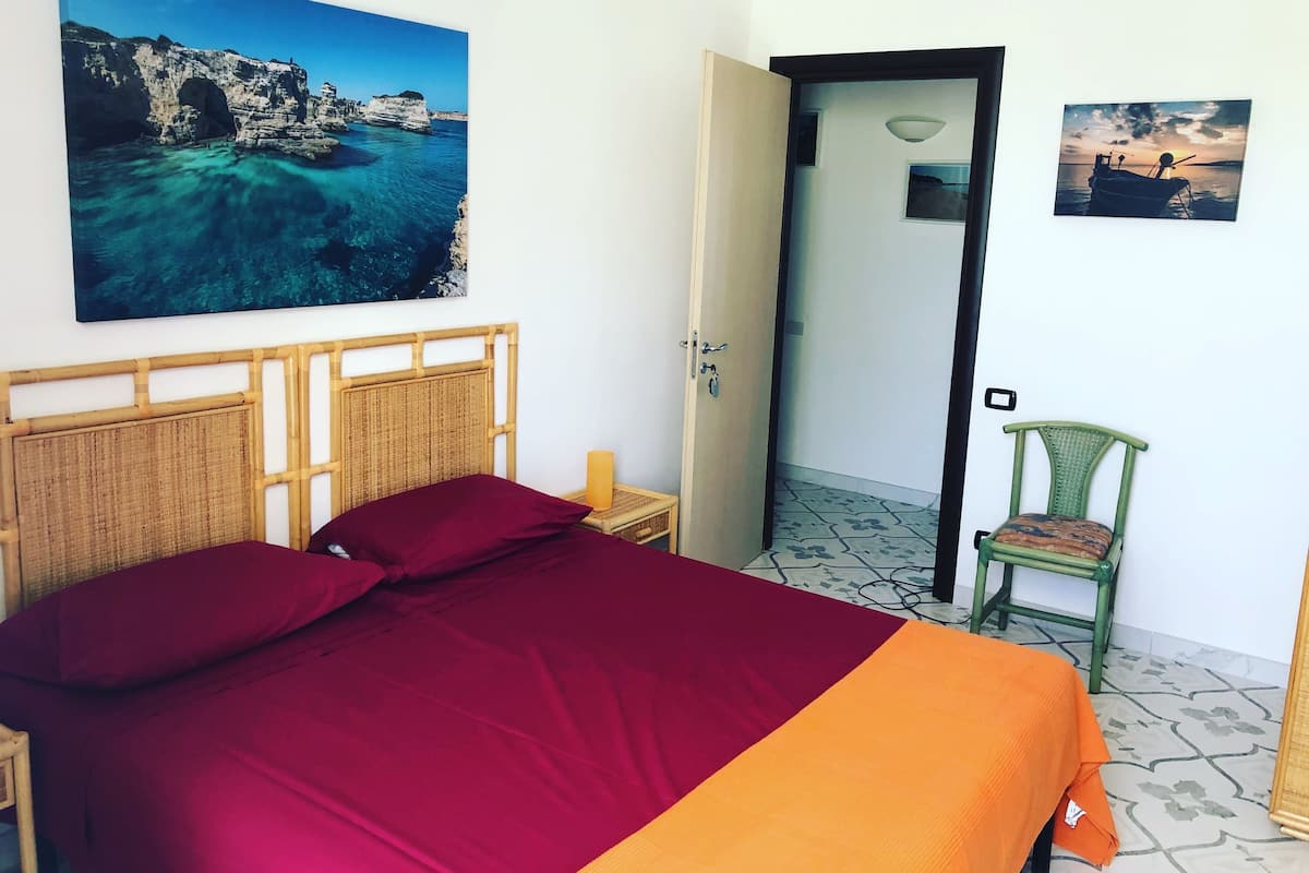 Une pièce comprenant un lit, une chaise et deux tableaux encadrés accrochés au mur.
