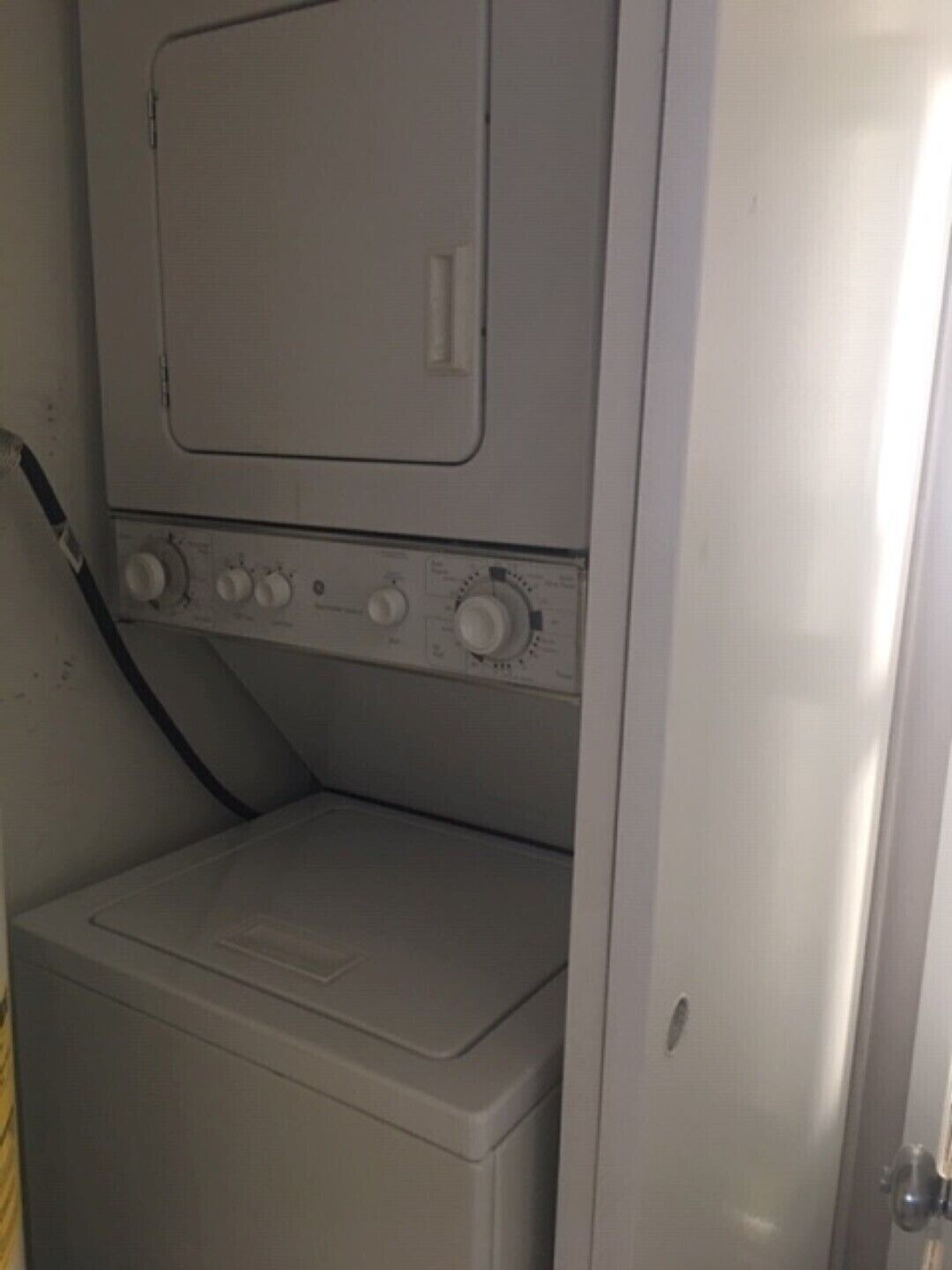 A compact, white laundry room with a built-in washer and dryer.