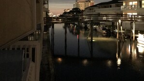 Ein Blick auf einen Kanal bei Nacht, mit einer Brücke und Gebäuden am gegenüberliegenden Ufer.