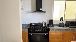 A kitchen with a black stove, oven, and a window.