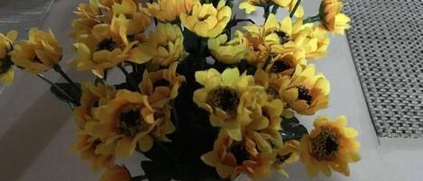 A table with a bouquet of yellow flowers.