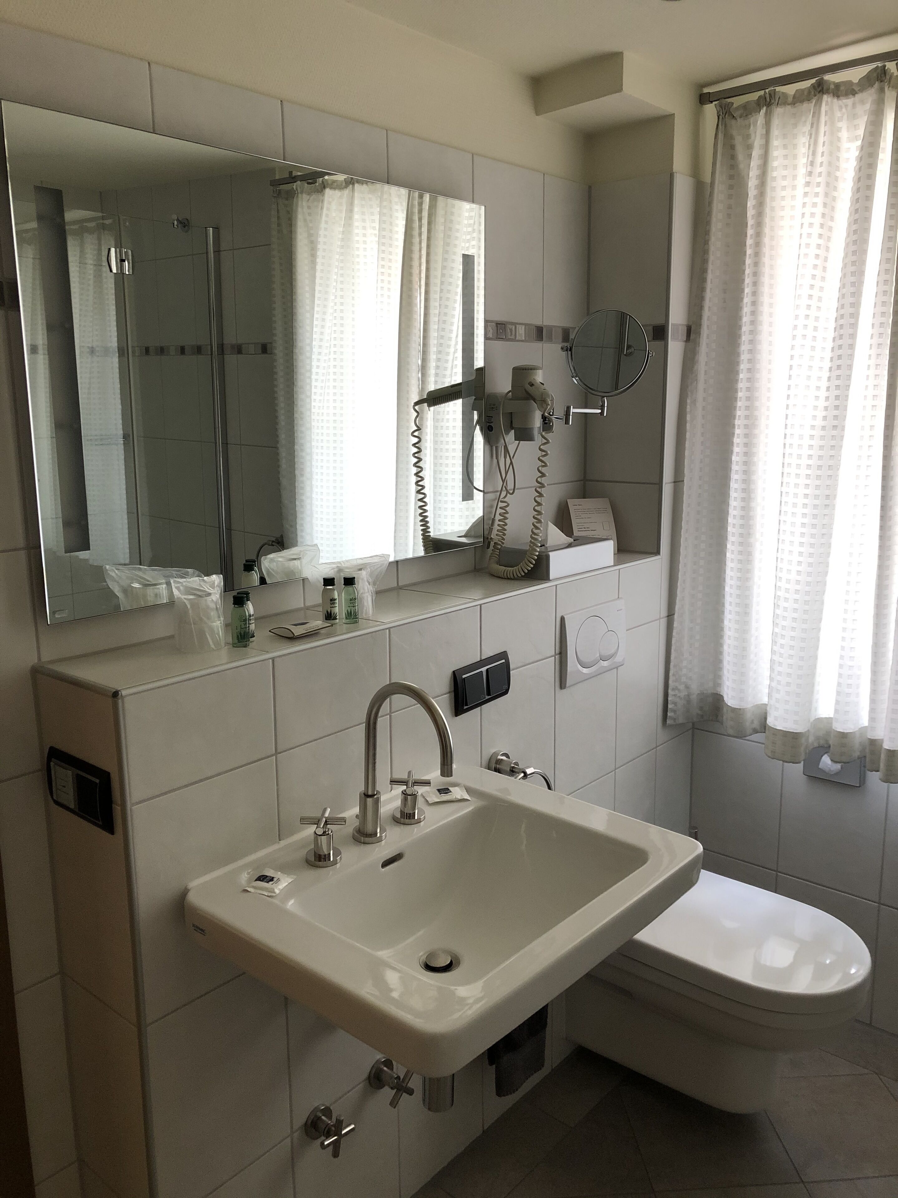 Een badkamer met een wastafel, spiegel en toilet.