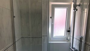 A modern bathroom with a glass-enclosed shower, a toilet, and a sink. - Apartment near the Sardinero (Santander)