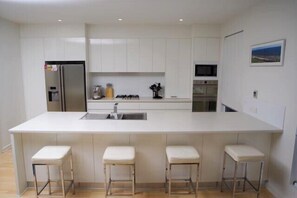 Enjoy cooking in this well-equipped kitchen with a large island, sink, and gas stove.