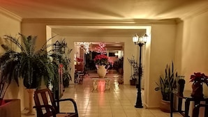 A spacious hallway with a tiled floor, flanked by potted plants and a rocking chair. - Mi Ca-Sa En Mérida (Mérida)