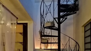 A spiral staircase with potted plants, a white interior, and a view of the sky. - Mi Ca-Sa En Mérida (Mérida)