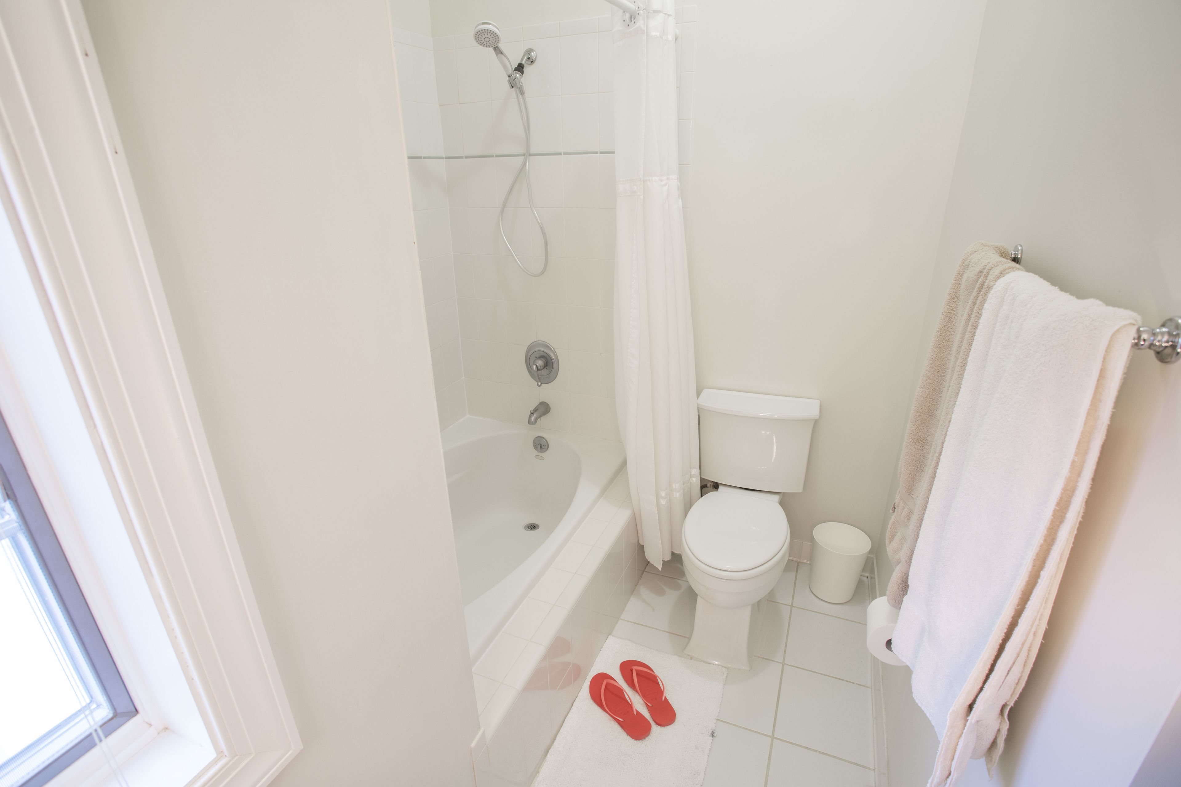 A bathroom with a bathtub, toilet, and a shower.