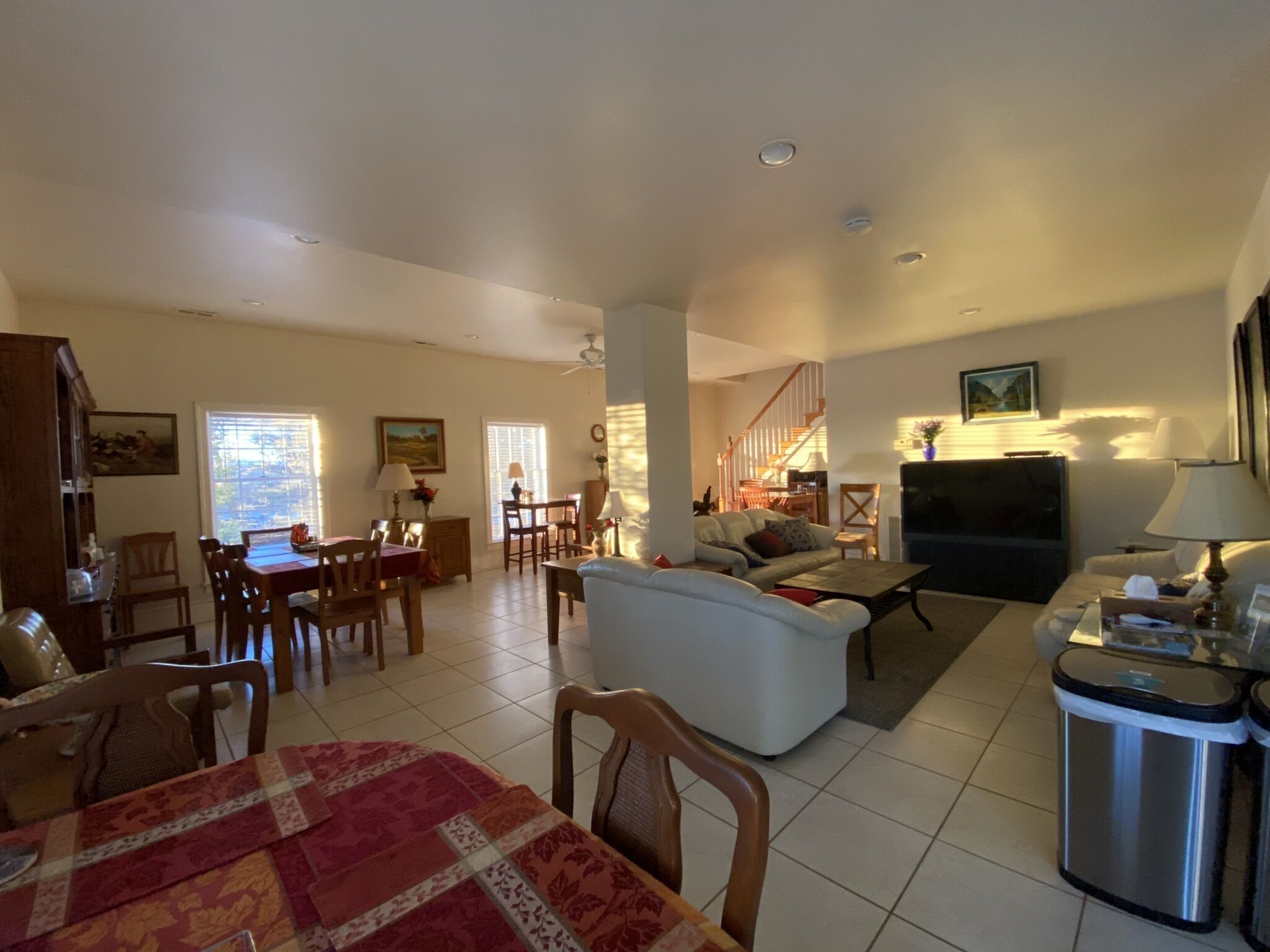A spacious living area with a dining table, sofa, and TV.