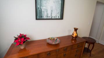 A wooden dresser with multiple drawers, a vase, and a bowl on top.