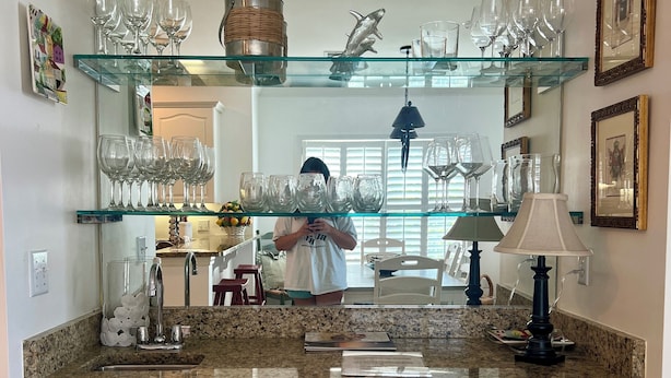 A kitchen with a granite countertop, a sink, a wine rack, and a mirror above the counter. - Great summer rates, Location, Views, Convenience...Golf/Pool/Fitness/Biking (Saint Simons Island)
