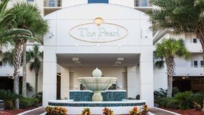 The Pearl hotel with a central fountain, palm trees, and a tiled entrance. - Pearl 1001 Completely renovated from floor to ceiling! Super clean!  (Navarre)