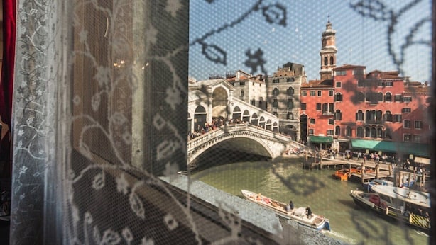 Une vue d’un pont historique enjambant une rivière, avec des bâtiments et des bateaux au premier plan.