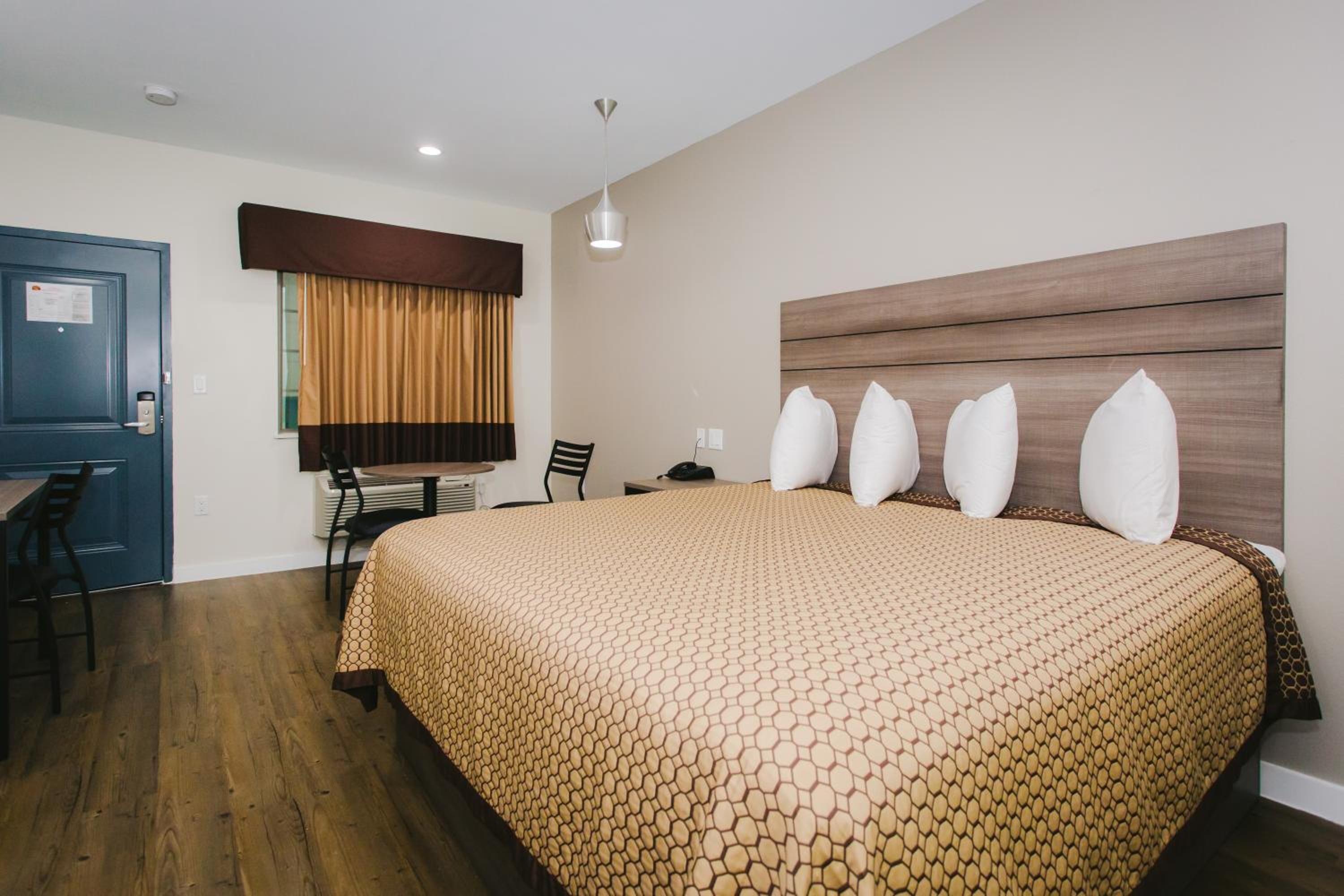 Una habitación de hotel con una cama grande, un escritorio y una silla.