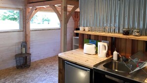 Una cocina compacta con vigas de madera, un lavamanos, un tostador y una cafetera.