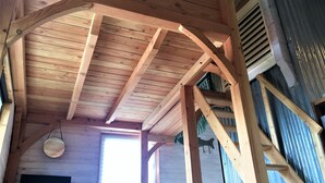 Estructura de techo de madera con un televisor y un jarrón de flores.