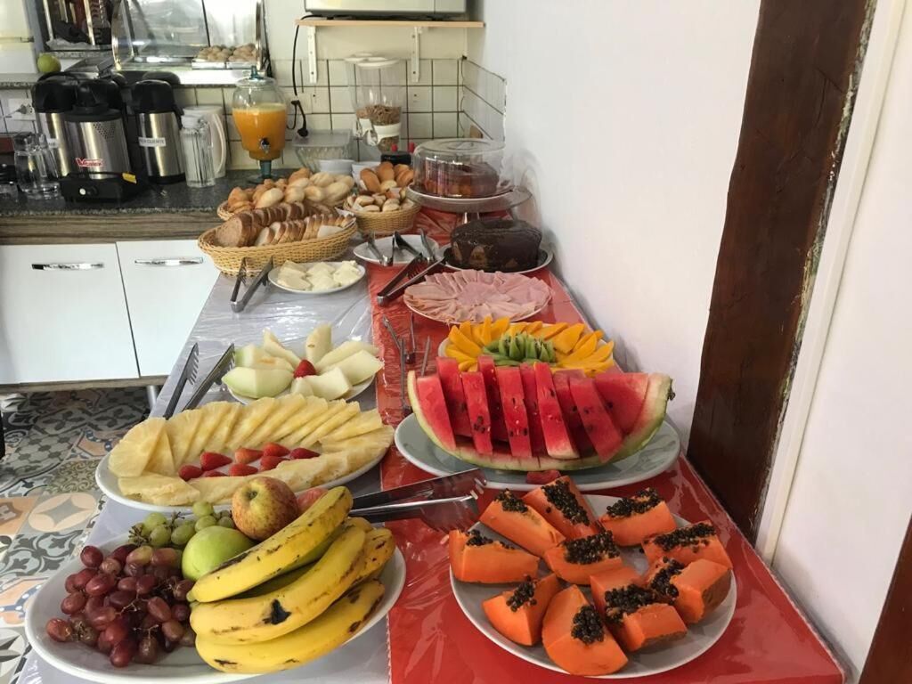 A breakfast buffet with various fruits, pastries, and beverages.