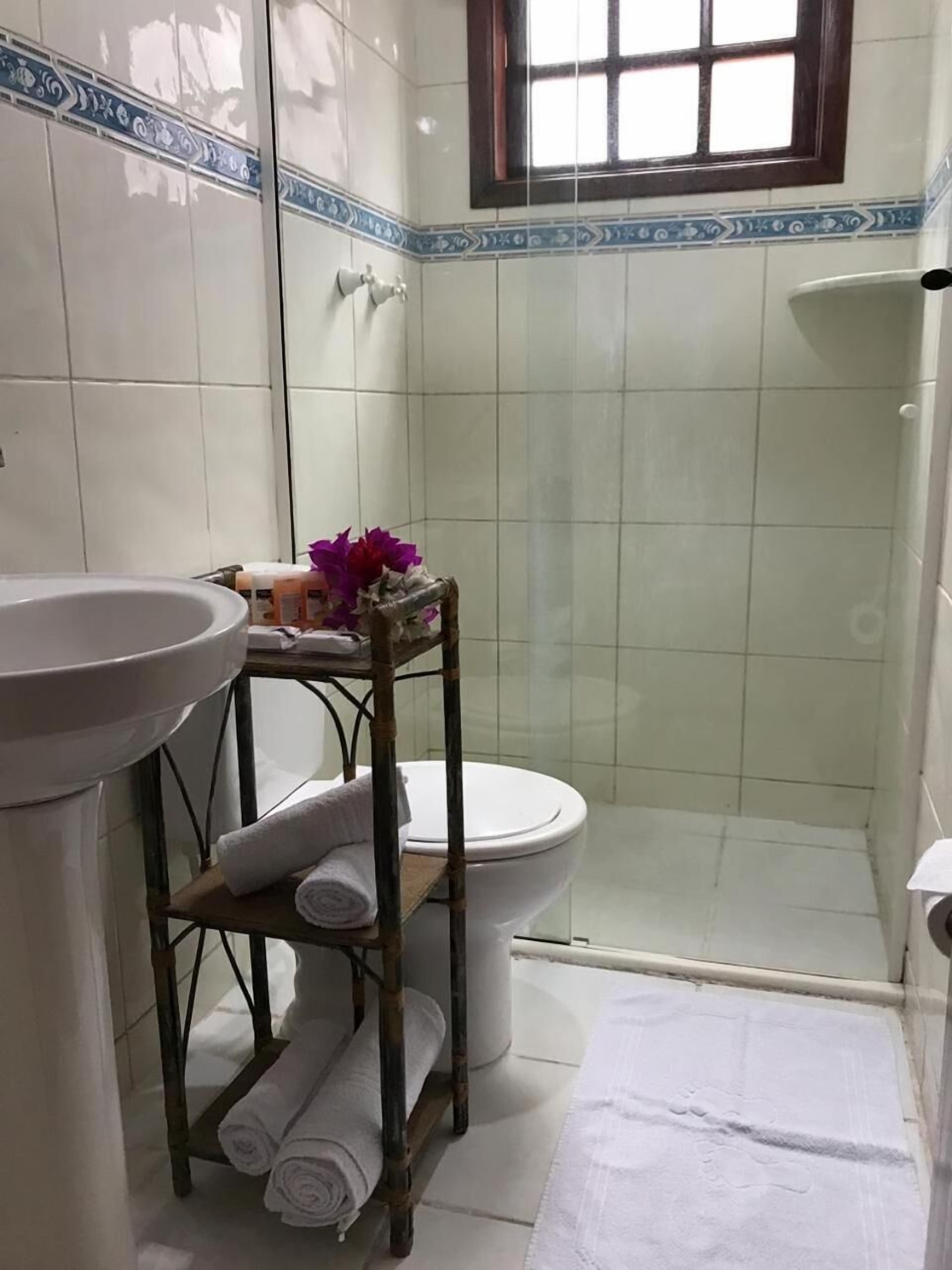 A bathroom with a toilet, a sink, and a shower area.