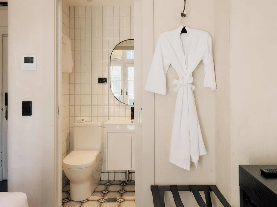 Een badkamer met toilet, wastafel en spiegel.
