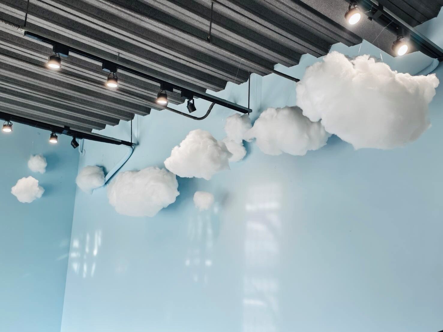 Techo decorado con motivos de nubes e iluminación empotrada.
