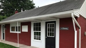 Un edificio rojo con una puerta negra y un cartel que dice "The Bakery".
