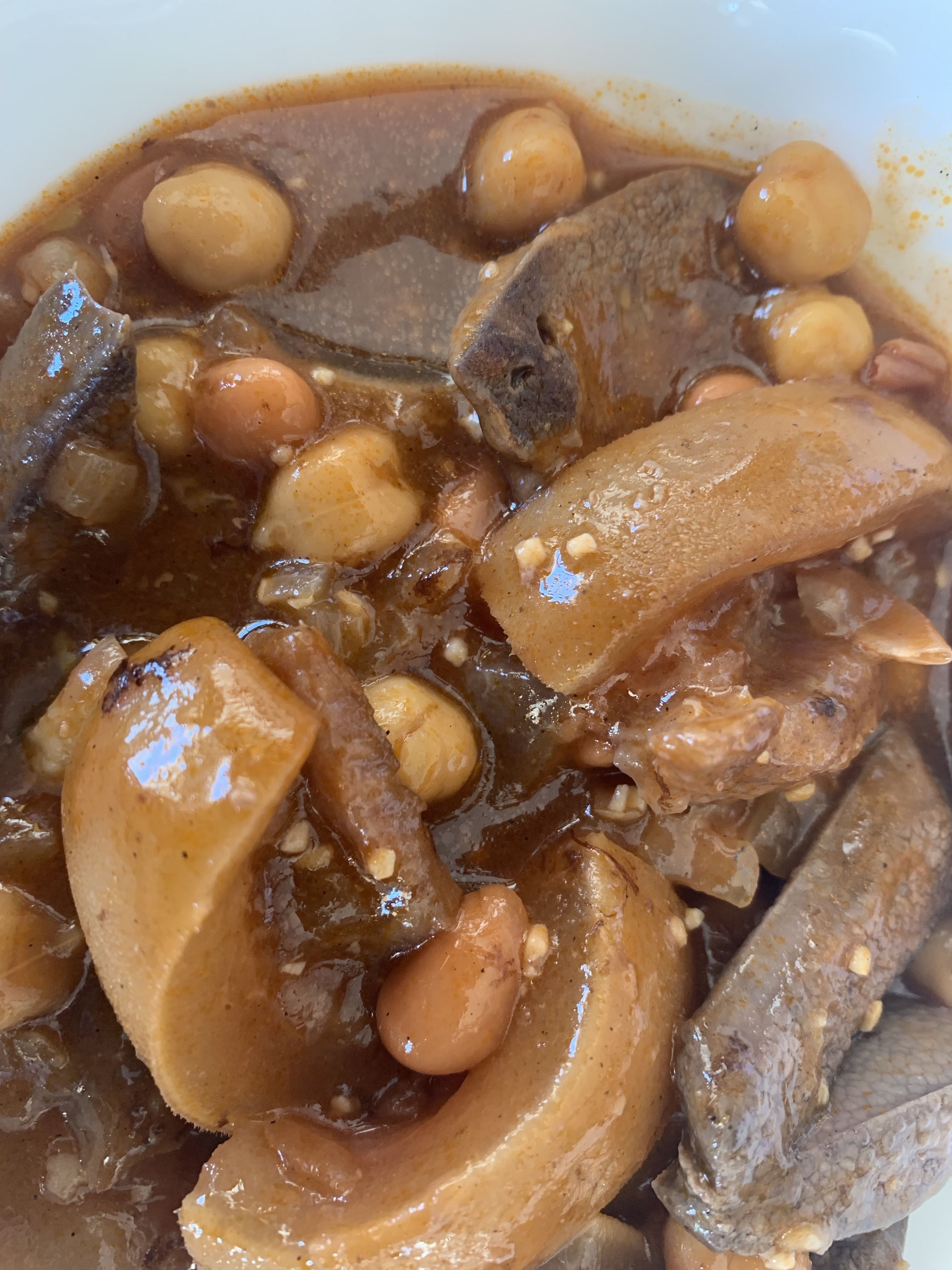 A close-up of a dish with various ingredients in a sauce.
