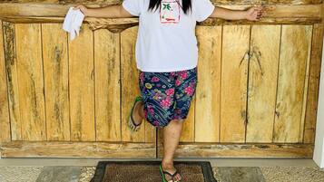 A person standing in front of a wooden door with a welcome mat.