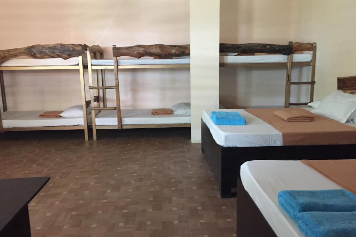 Ein Zimmer mit Etagenbetten, einer Holzleiter und einem Schreibtisch.