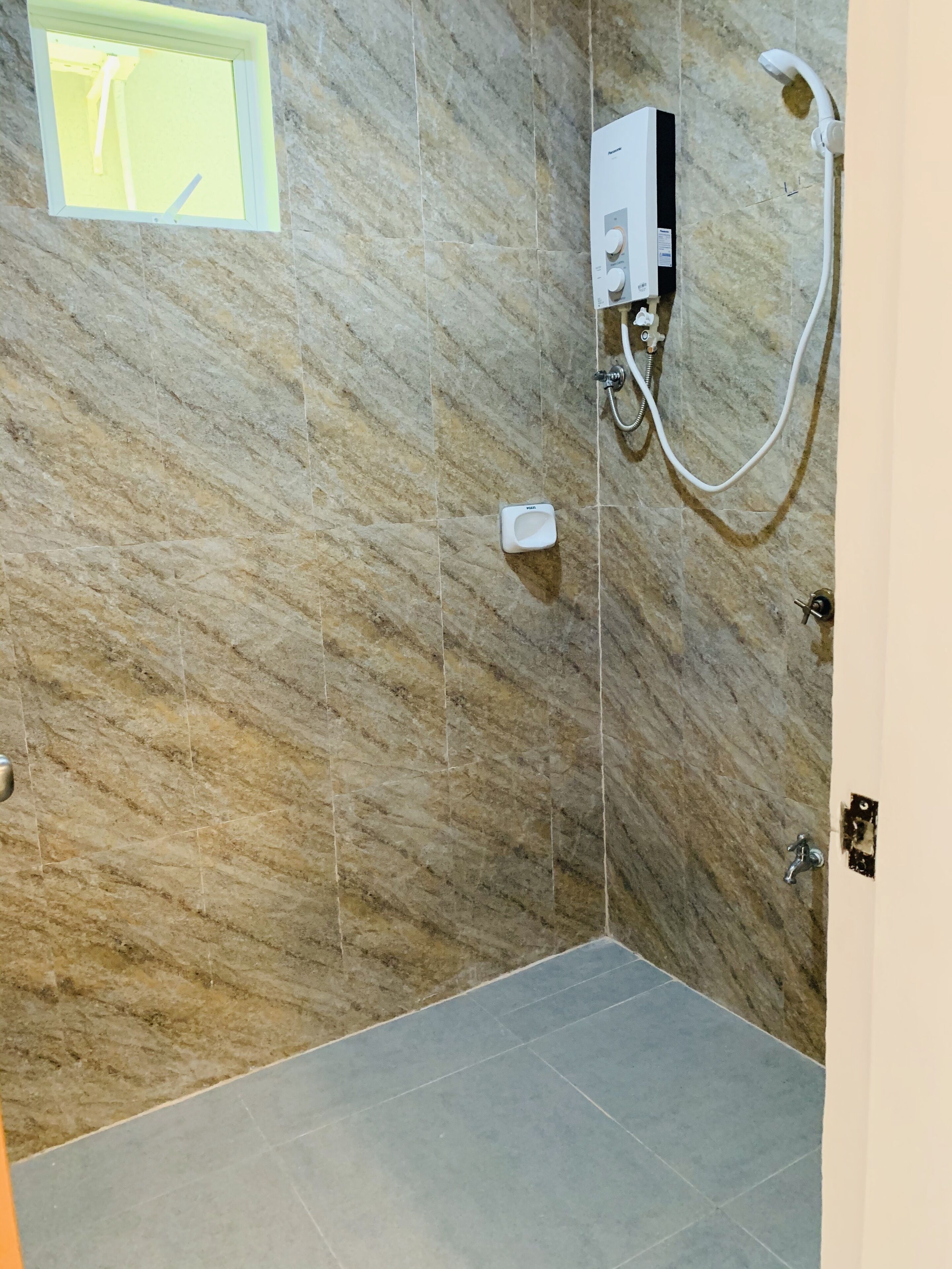 Un baño con ducha, inodoro y ventana.