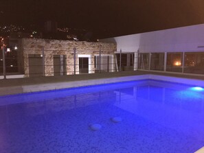 Una piscina al aire libre, sombrillas
