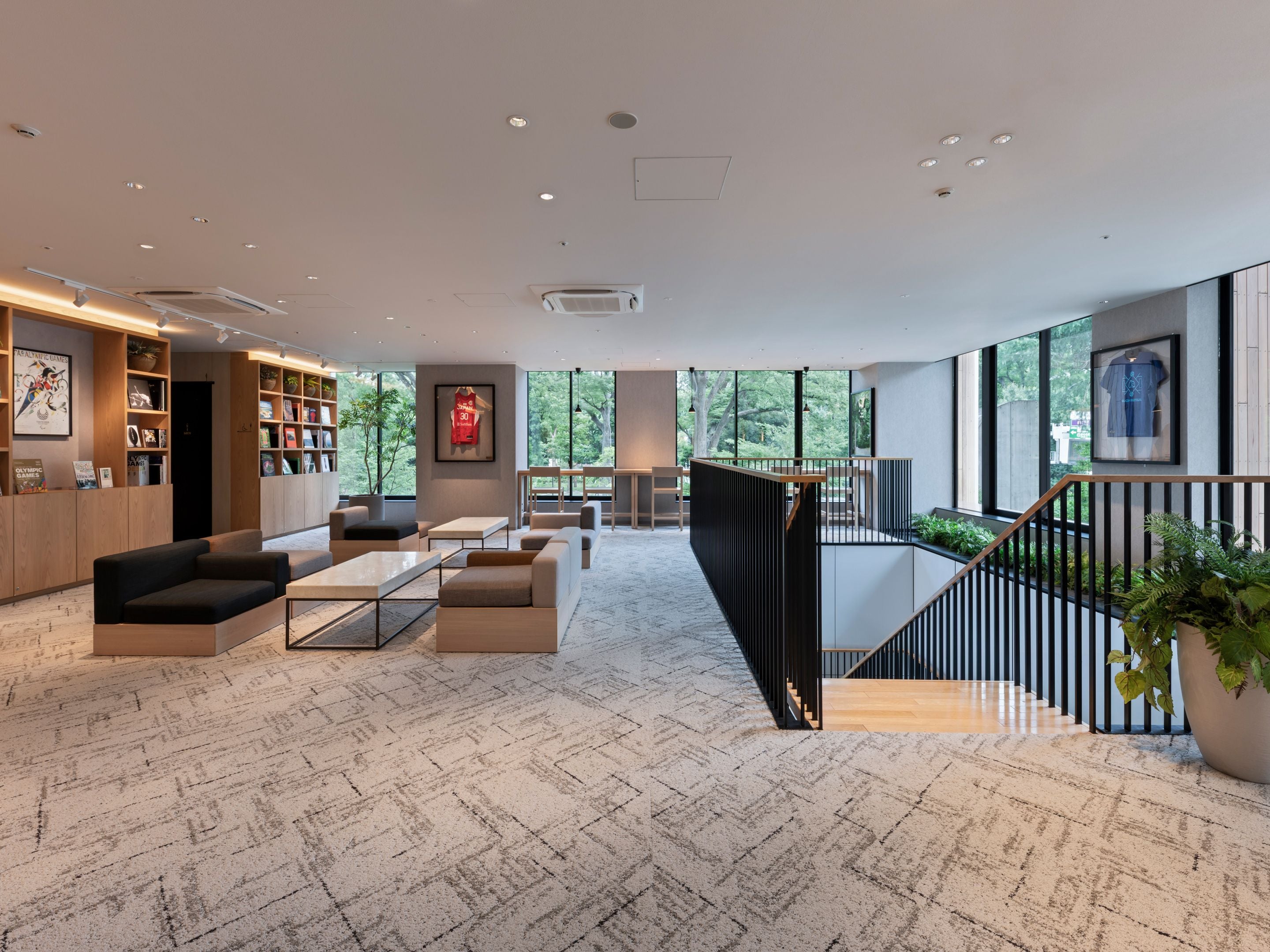 Un interior moderno con una zona de estar, estanterías y una escalera.
