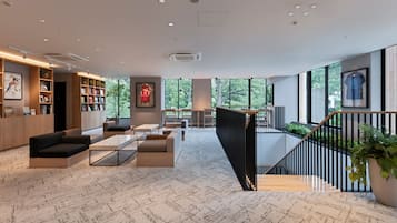 Un interior moderno con una zona de estar, estanterías y una escalera.