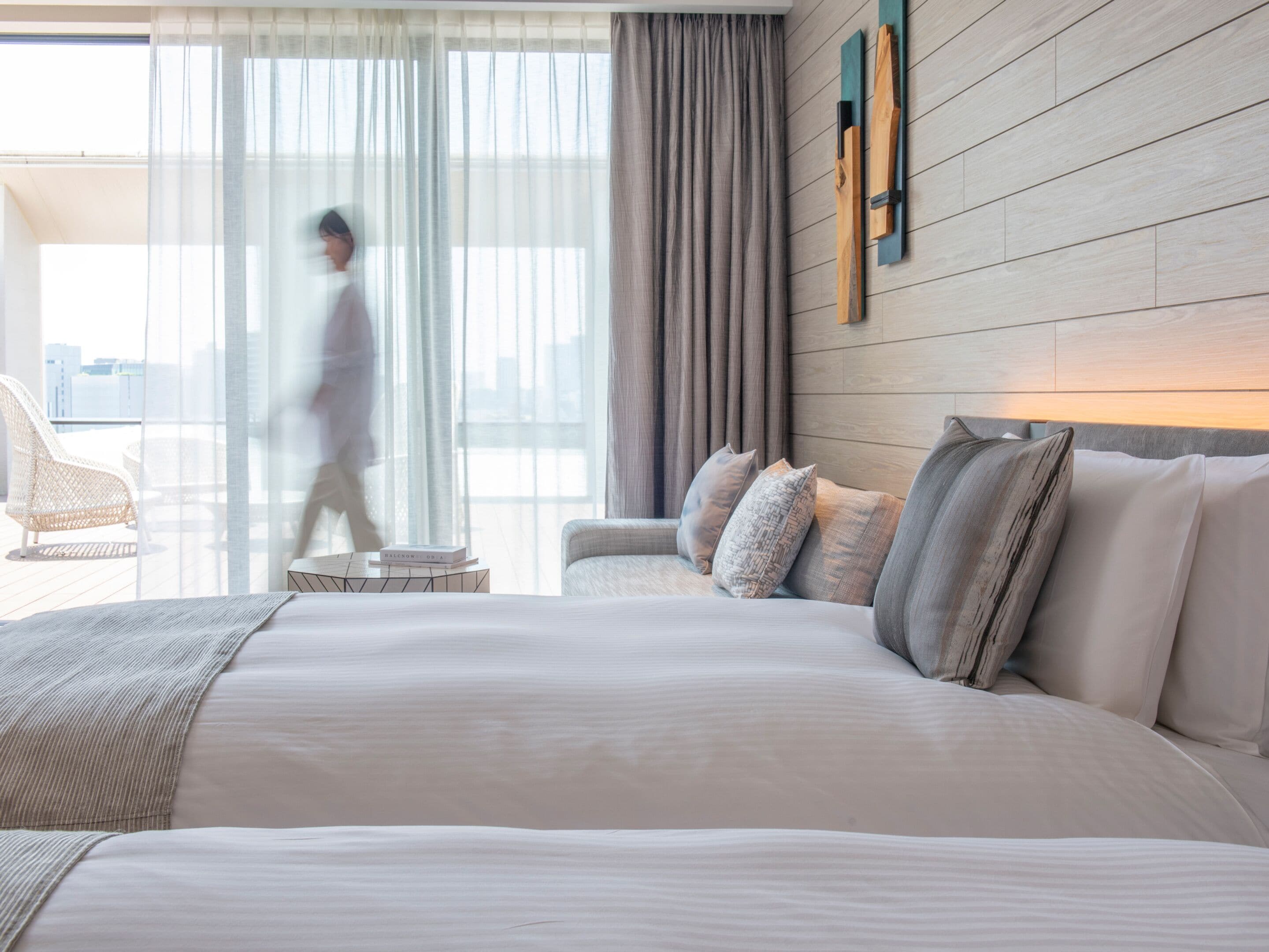 Une chambre d’hôtel moderne avec un grand lit, un canapé et un balcon  équipé d’une chaise.