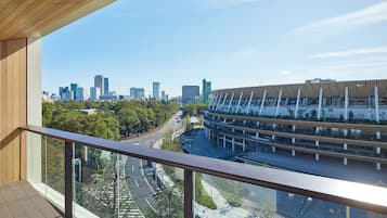 Ein modernes Gebäude mit einem einzigartigen Dachdesign, im Hintergrund eine Stadtansicht und ein Blick auf eine Straße mit einer Straßenbahn.