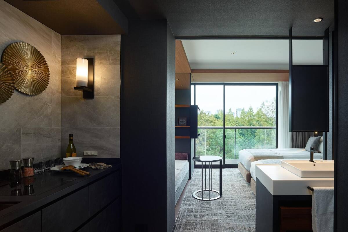 A modern bathroom with a large window, a sink, and a mirror.