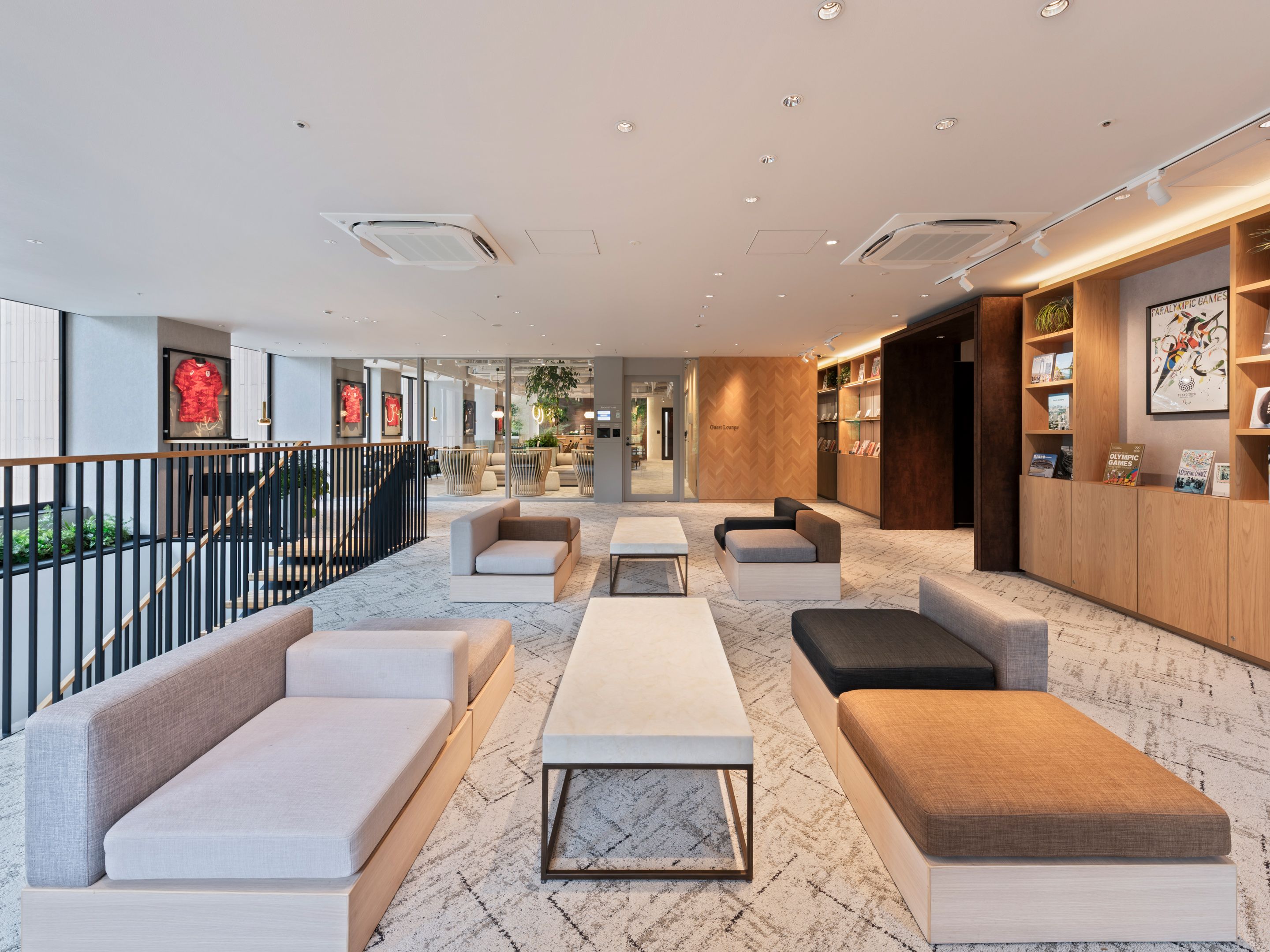 Un área de estar moderna con asientos, una recepción y vistas al exterior.