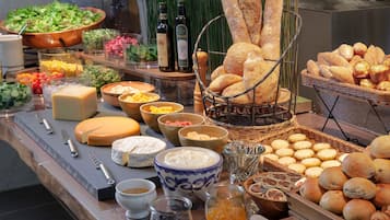 A buffet with various cheeses, breads, and condiments.