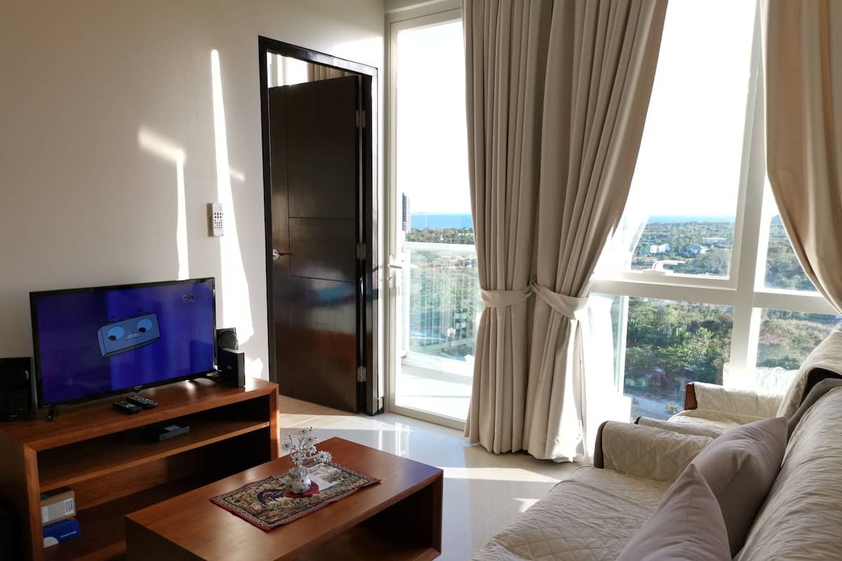 One Pacific Residences 1D | Área de sala de estar | Televisión de pantalla plana de 32 pulgadas con canales por cable