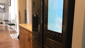 Una cocina con refrigerador de acero inoxidable, armarios de madera y una encimera.