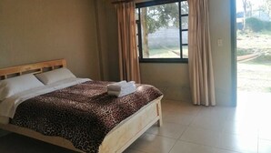 A bedroom with a bed, curtains, and a window. - Hostería El Tisaleño (Tizaleo)