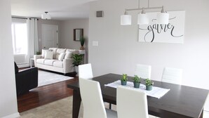 A dining area with a dark wooden table, white chairs, and potted plants. - Small Home Paradise - close to Lancaster attractions (Paradise)